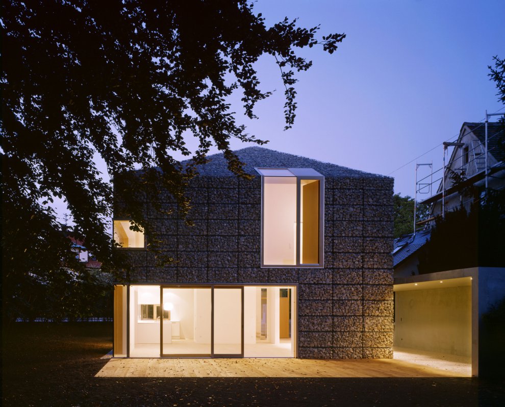 architizer:

The burly curtain wall (365 hand-filled cages packed with 40,000 stones) in contrast to the light interiors and the plate glass windows sends shivers up our collective spine.
House 9x9 by Titus Bernhard Architekten.

Heavy/Light